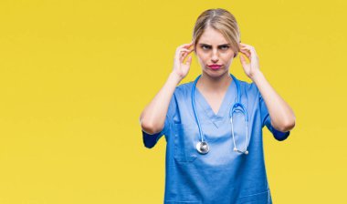 Genç güzel sarışın doktor cerrah hemşire kadın parmakları ile yüksek sesle müzik gürültü rahatsız ifade kulaklarıyla kapsayan izole arka plan yüzünden. Sağır kavramı.