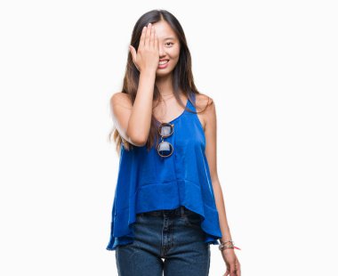 El yüz ve sürpriz duygu kendinden emin gülümseme ile tek gözüyle kapsayan izole arka plan üzerinde Genç Asyalı kadın.