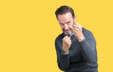 Bir kazak izole üzerinde giyen yakışıklı orta yaş üst düzey adam arka plan yumruk savunma hareketi, kızgın ve üzgün yüz, sorunu korkuyor ile savaşmaya hazır