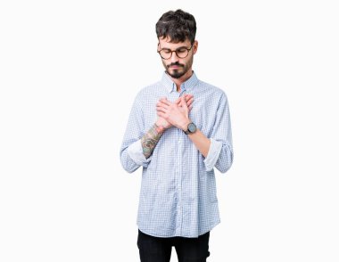 Yakışıklı delikanlı ile gülümseyen izole arka plan üzerinde gözlük takan kapalı gözler ve yüzünde minnettar jest ile göğüs üzerinde eller. Sağlık kavramı.