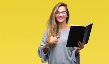 Genç güzel sarışın kadın kendisine sürpriz yüz işaret parmağı izole arka plan üzerine bir kitap okuma
