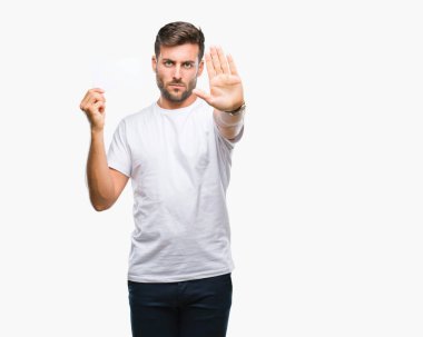 Yakışıklı delikanlı ile izole arka plan üzerinde boş kartı tutan el dur işareti ile ciddi ve kendine güvenen ifade, savunma jest yapıyor açın