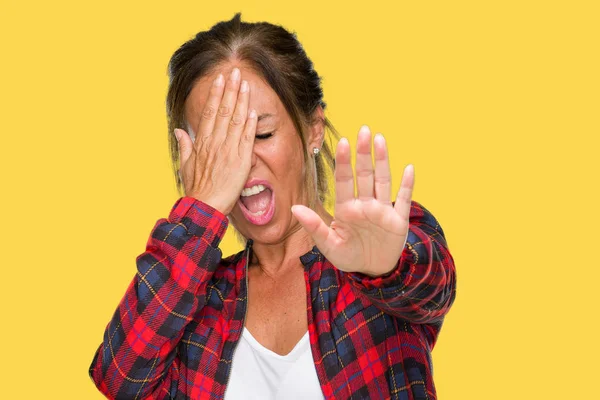 Middle age adult woman wearing casual jacket over isolated background covering eyes with hands and doing stop gesture with sad and fear expression. Embarrassed and negative concept.