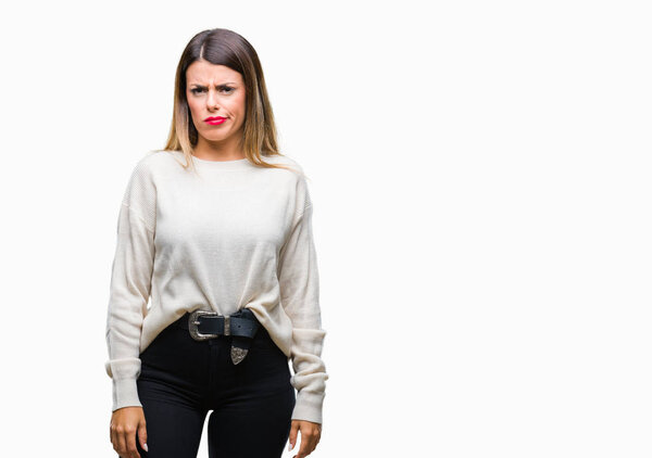 Young beautiful woman casual white sweater over isolated background skeptic and nervous, frowning upset because of problem. Negative person.
