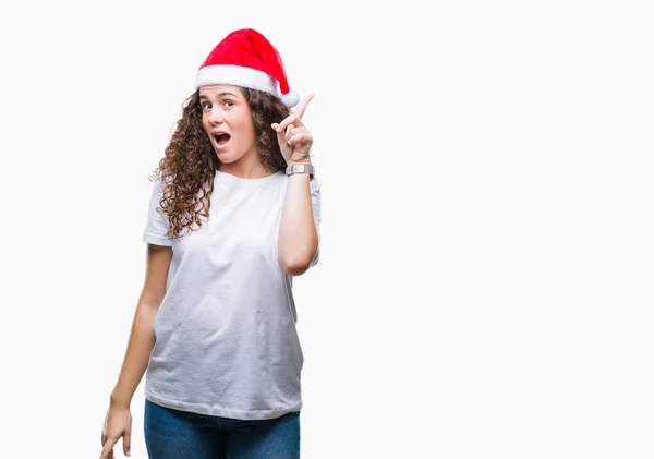 年轻的黑发女孩戴着圣诞帽在孤立的背景指向手指与成功的想法 离开和快乐 — 图库照片