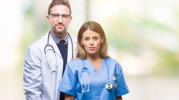 Casal Jovem Médico Cirurgião Sobre Fundo Isolado Com Expressão Séria — Fotografia de Stock