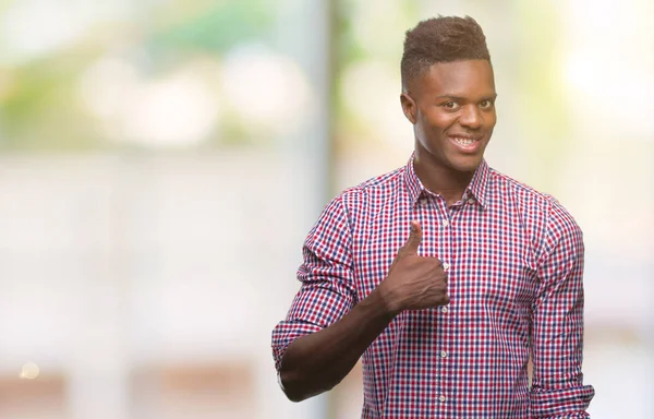 年轻的非洲裔美国人在孤立的背景下做快乐拇指手势与手 批准表达式看相机与显示成功 — 图库照片