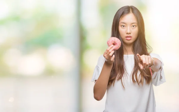 Joven Mujer Asiática Comiendo Donut Sobre Fondo Aislado Señalando Con —  Fotos de Stock