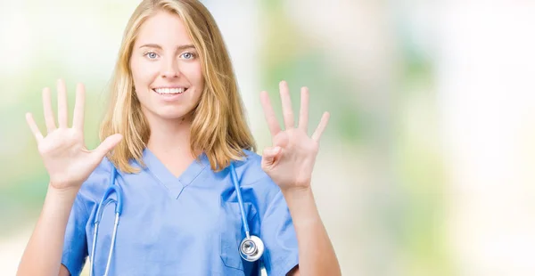 孤立した背景表示と指で上向きに医療制服を着て美しい女医女性ナンバー ナイン自信を持って 幸せな笑みを浮かべて — ストック写真