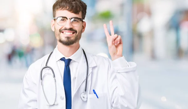 Junger Arzt Trägt Krankenhausmantel Über Isoliertem Hintergrund Und Zeigt Mit — Stockfoto