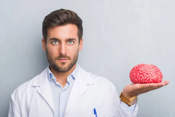 Bonito Jovem Médico Psicólogo Homem Sobre Parede Grunge Cinza Segurando — Fotografia de Stock