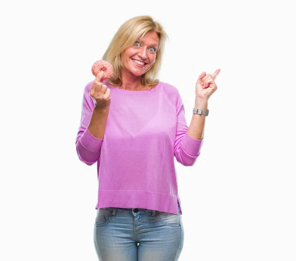 Blonde Frau Mittleren Alters Isst Rosa Donut Über Isoliertem Hintergrund — Stockfoto