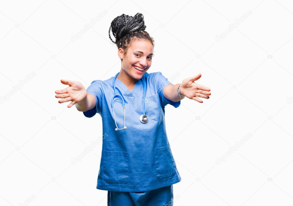 Young braided hair african american girl professional surgeon over isolated background looking at the camera smiling with open arms for hug. Cheerful expression embracing happiness.