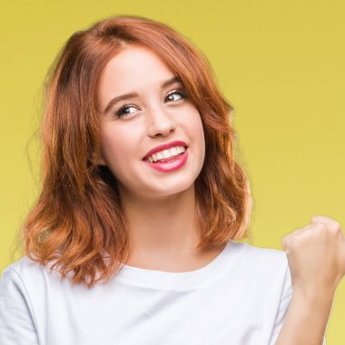 Seyir ve başparmak yanında yukarıyı mutlu yüz ile gülümseyen izole arka plan üzerinde genç güzel kadın.