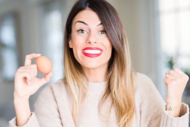 Duygu tezahürat ev gurur çığlık ve kutluyor zafer ve başarı, taze yumurta çok heyecanlı, tutan genç güzel kadın