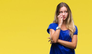 Genç güzel sarışın kadın yüzünden stresli ve gergin ile izole arka plan tırnak ısırma dudaklarından eller. Anksiyete sorunu.