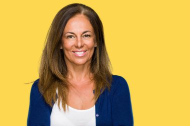 İzole arka plan mutlu yüz çapraz silah kameraya bakarak ile gülümseyen güzel orta yaş rahat yetişkin kadın. Olumlu bir kişi.