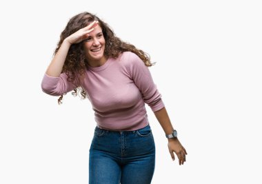 Güzel esmer kıvırcık saçlı Genç kız çok mutlu ve gülümseyen uzakta el ile üzerine kafa seyir izole arka plan üzerinde pembe kazak giyiyor. Arama kavramı.