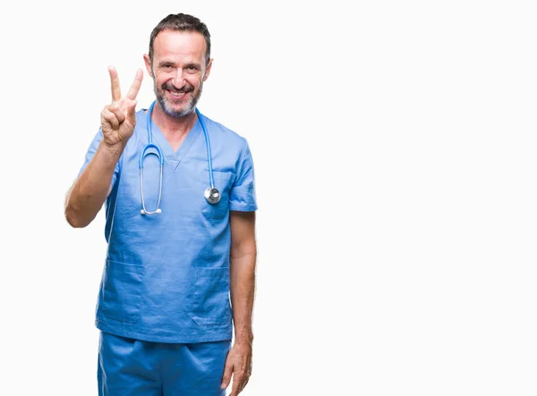 中年老人穿着医疗制服在孤立的背景显示和指向手指第二 而微笑着自信和快乐 — 图库照片