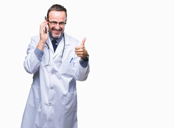 中年老年白发医生在智能手机上交谈孤立的背景高兴与灿烂的微笑做确定的标志 用手指竖起大拇指 优秀的标志 — 图库照片