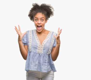 Genç afro Amerikan kadın deli kutluyor ve silah ile başarı için heyecanlı çığlık kaldırdı ve açık gözleri hayret izole arka plan yüzünden. Kazanan kavramı