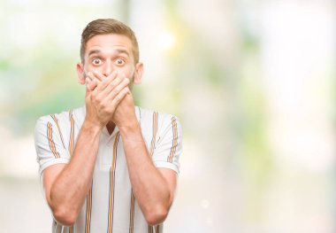 Yakışıklı delikanlı izole arka plan ağız hata için elleriyle kapsayan şok içinde. Gizli kavramı.