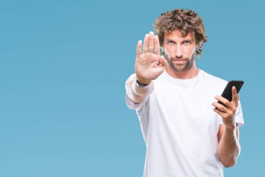 İspanyol yakışıklı modeli açık eliyle dur işareti ile ciddi ve kendine güvenen ifade, savunma jest yapıyor izole arka plan üzerinde Smartphone kullanarak mesaj mesaj gönderme