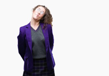 Okul üniforması ve gözlük üzerinde giyen genç esmer öğrenci kız arka plan yapma balık yüz dudaklı, çılgın ve komik bir jest izole. Komik ifade.