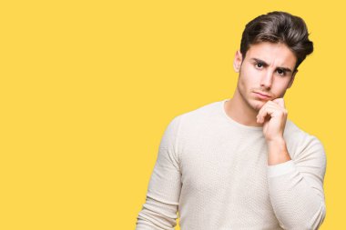 Yakışıklı delikanlı çene düşünme hakkında soru, dalgın ifade üzerine el ile izole arka plan üzerinde. Düşünceli yüzüyle gülümsüyor. Şüphe kavramı.