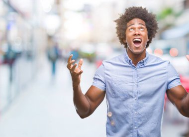 Afro Amerikalı adam izole arka plan çılgın ve kızgın bağırarak ve agresif ifade ve silah kaldırdı bağırıyor. Hayal kırıklığı kavramı.