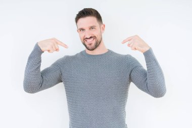 Yüzünde gülümseme ile kendinden emin görünüyorsun, kendini gururlu ve mutlu parmakları ile işaret izole arka plan üzerinde rahat kazak giyen genç yakışıklı adam.
