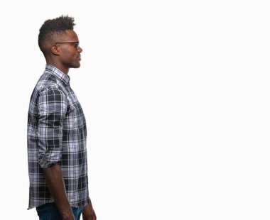 Genç Afro-Amerikan adam giyen güneş gözlüğü izole arka tarafına, seyir üzerinde dinlenmek doğal yüz emin gülümseme ile pozuyla profili.