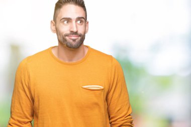 Yakışıklı delikanlı görünümlü yan ve dik dik bakma uzağa düşünce gülümseyen izole arka plan üzerinde.