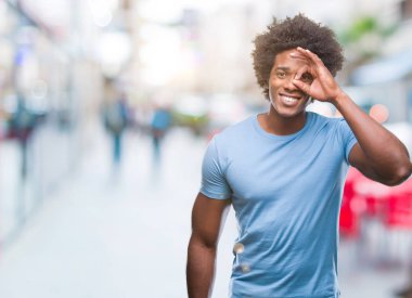Afro Amerikalı adam gülümsüyor, parmakları ile mutlu yüz üzerinden seyir göz el ile ok jest yapıyor izole arka plan üzerinde.