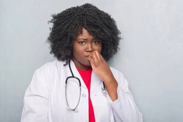 Joven Africana Americana Médico Mujer Sobre Gris Grunge Pared Buscando —  Fotos de Stock