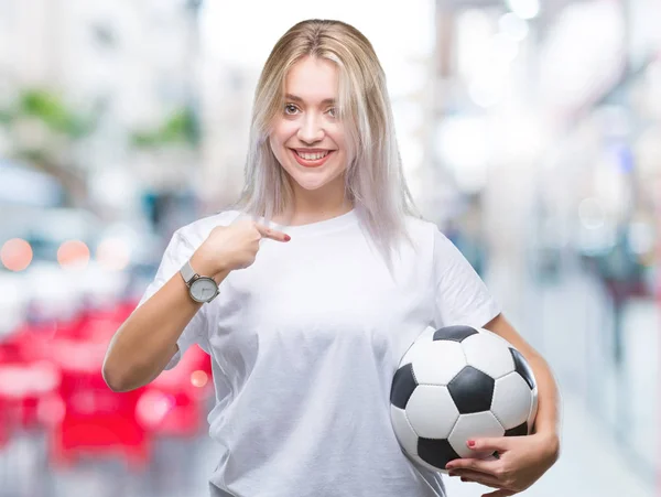 Junge Blonde Frau Hält Fußballball Über Isoliertem Hintergrund Mit Überraschendem — Stockfoto