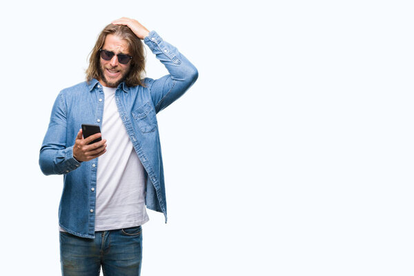 Young handsome man with long hair over isolated background sending message using smartphone stressed with hand on head, shocked with shame and surprise face, angry and frustrated. Fear and upset for mistake.
