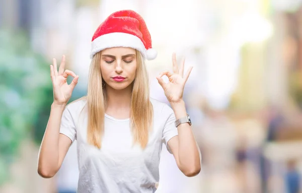 年轻美丽的金发碧眼的女人圣诞帽在孤立的背景放松和微笑与眼睛闭着做冥想手势用手指 瑜伽概念 — 图库照片