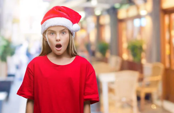 驚きの表現 恐怖と興奮した顔でショックを受けて孤立した背景にクリスマス帽子身に着けている美しい少女 — ストック写真