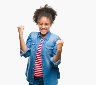 Gülümseyen ve başarı için çığlık genç afro Amerikan kadın izole arka plan çok mutlu ve heyecanlı kaldırdı, silah ile kazanan jest yapıyor. Kutlama kavramı.