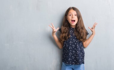 Grunge genç İspanyol çocuk duvar kutluyor deli gri ve çığlık kaldırdı ve açık gözleri heyecanlı silah ile başarı için hayrete düşürdü. Kazanan kavramı