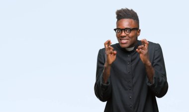 Umut ve gözleri kapalı geçiş parmaklarıyla gülümseyen izole arka plan genç Afro-Amerikan rahip adam. Şans ve batıl kavramı.