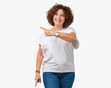 İzole arka neşeli bir gülümseme ile el ve parmak kadar yan yüzünde mutlu ve doğal ifade ile işaret yüz üzerinden beyaz t-shirt giyen güzel orta ager üst düzey kadın