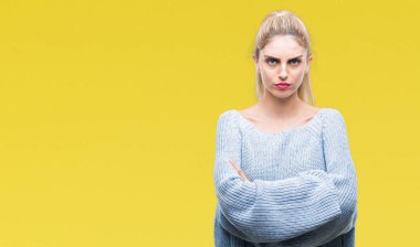 İzole arka plan şüpheci ve sinir, onaylamayan ifade yüz çapraz kolları üzerinde kış kazak giyen genç güzel sarışın ve mavi gözlü kadın. Negatif kişi.