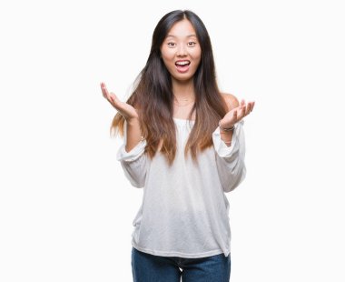 Genç Asyalı kadın deli kutluyor ve silah ile başarı için heyecanlı çığlık kaldırdı ve açık gözleri hayret izole arka plan üzerinde. Kazanan kavramı