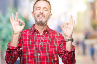Orta yaş ağarmış komuta sizde izole arka plan üzerinde dinlenmek ve gülümseyen gözlerle kapalı parmak jestle meditasyon yapıyor. Yoga kavramı.
