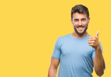 Yakışıklı delikanlı hareketi el ile mutlu yaşasın yapıyor izole arka plan üzerinde. Kameraya bakarak başarı gösteren ile ifade onaylama.