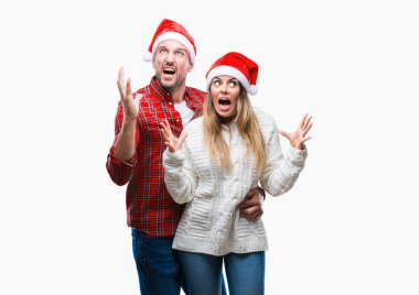 Üzerinde Noel şapka aşık genç çift arka plan çılgın ve kızgın bağırarak ve agresif ifade ve silah kaldırdı bağırmaya izole. Hayal kırıklığı kavramı.