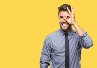 Genç yakışıklı iş adamı gülümseyen, parmakları ile mutlu yüz üzerinden seyir göz el ile ok jest yapıyor izole arka plan üzerinde.