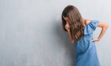 Genç İspanyol çocuk hasta ve soğuk veya bronşit için semptom olarak öksürük duygu grunge gri duvar için. Sağlık kavramı.